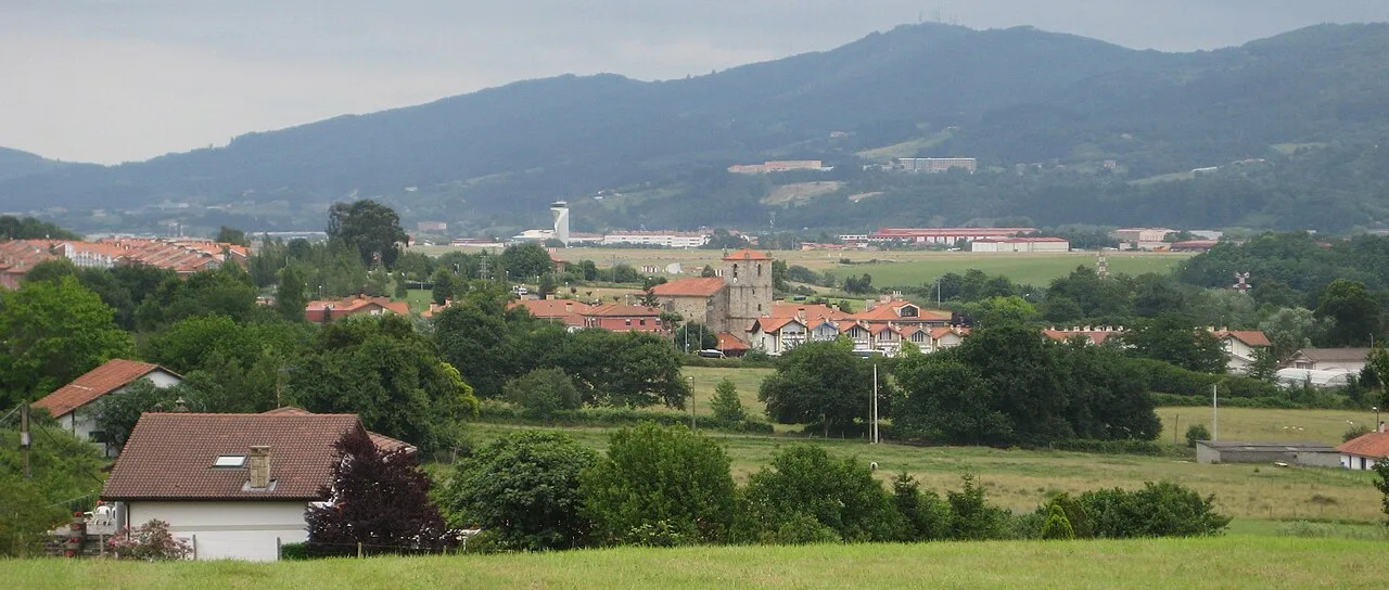 Landscape with houses, trees, and Bilbao airport control tower in Loiu.