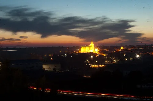 Nachtansicht von Villanueva de la Jara mit beleuchteter Kirche und Dämmerungshimmel.