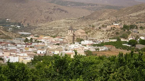 Vista del pueblo de Huécija con casas blancas y una iglesia en el centro.