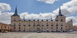 Facade of Lerma Ducal Palace with multiple windows and towers on top.