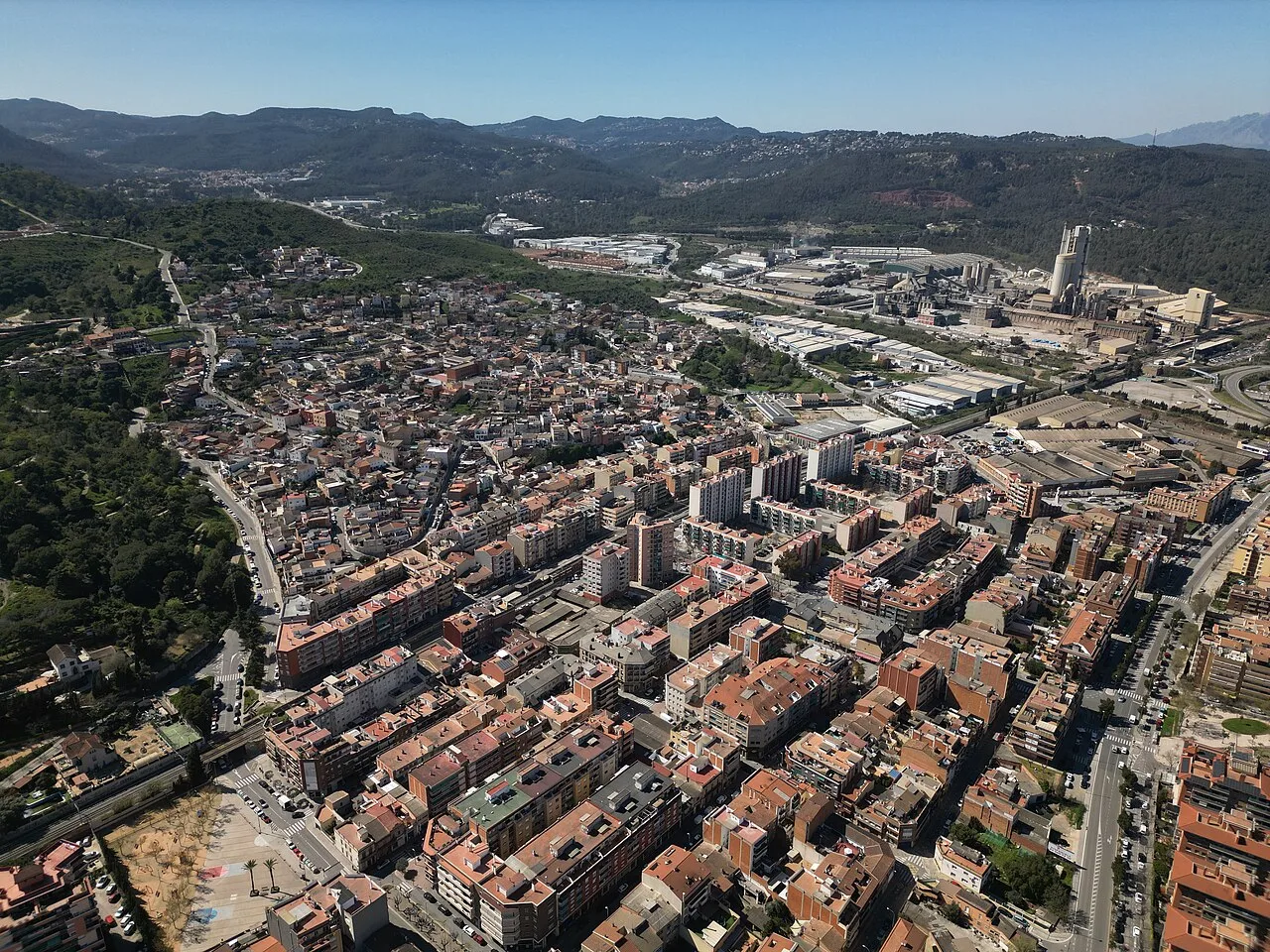 Luftaufnahme einer Stadt mit Straßen, Gebäuden und Bergen im Hintergrund