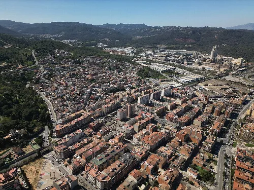 Luftaufnahme einer Stadt mit Straßen, Gebäuden und Bergen im Hintergrund