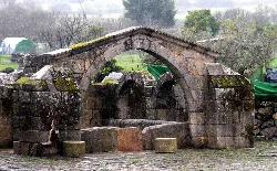Stone fountain with three arches and tiled roof in Zarza la Mayor.