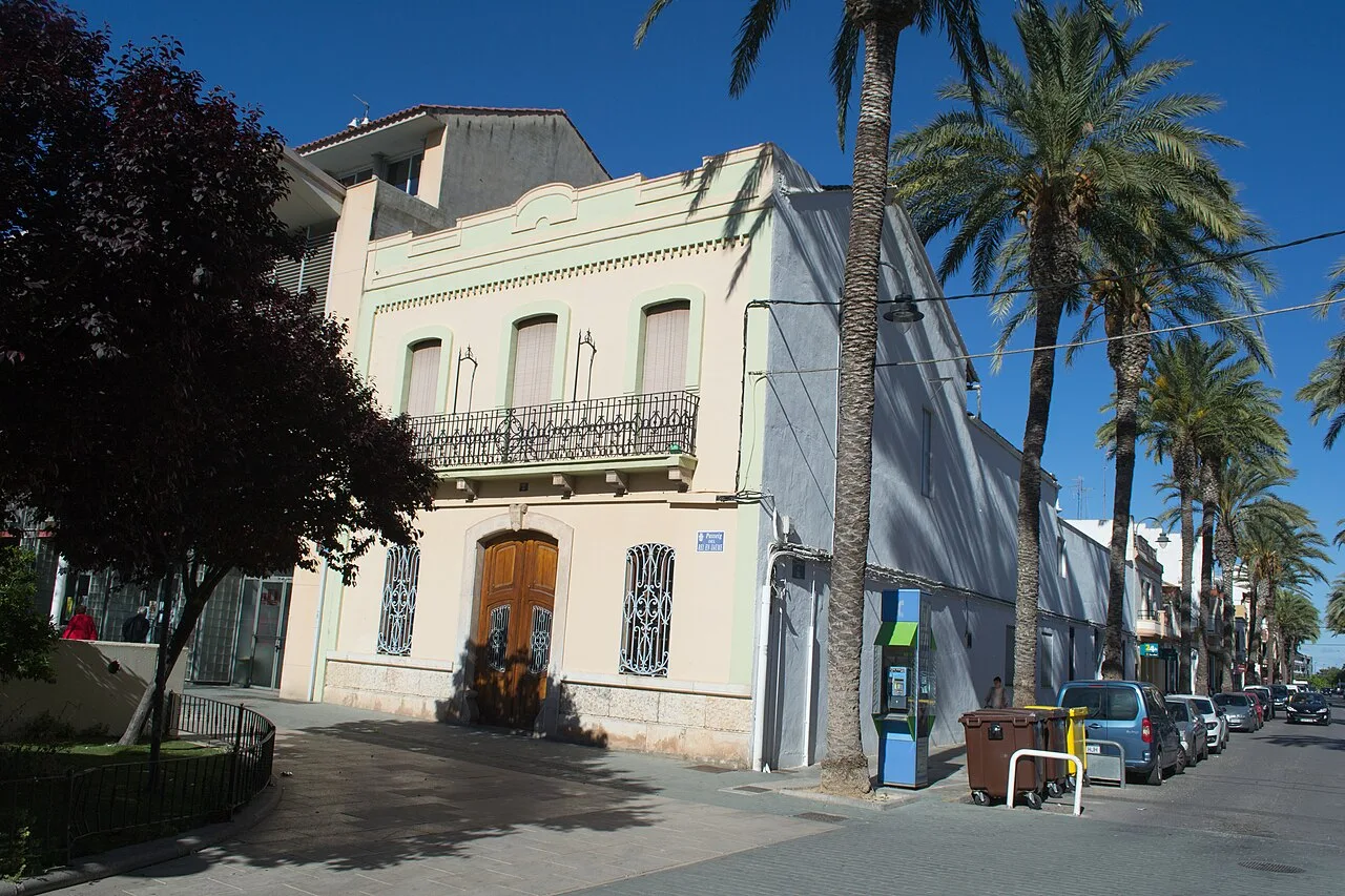 Edificio blanco con balcón y palmeras en la calle Paseo del Rey En Jaume en Masamagrell.