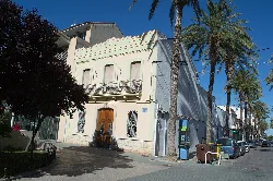 Edificio blanco con balcón y palmeras en la calle Paseo del Rey En Jaume en Masamagrell.