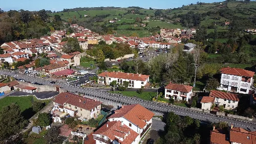 Panorámica de Santillana del Mar con casas y colinas verdes.