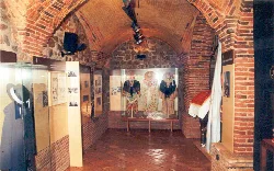 Interior view of the museum with traditional costumes and brick display cases.