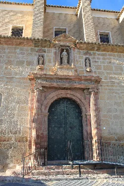 Stone facade with portal and sculptures at Santo Domingo Church, Mula.