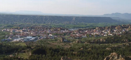 Panoramablick auf Purullena vom Flachland mit Bergen im Hintergrund.