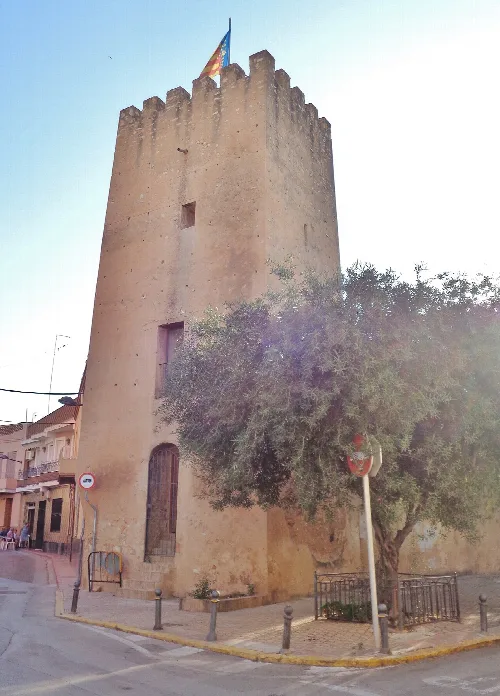 Steinturm mit Flaggen oben in einer Straße von Albal.