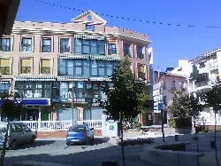 Modern building and trees in Plaza 1º de Mayo in Huétor-Tájar.