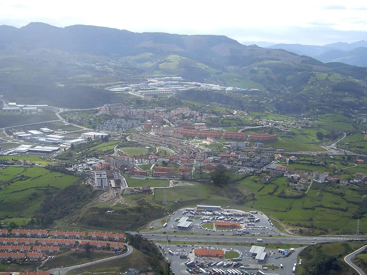 Vista aérea de Gallarta, con montañas y viviendas en un paisaje verde.