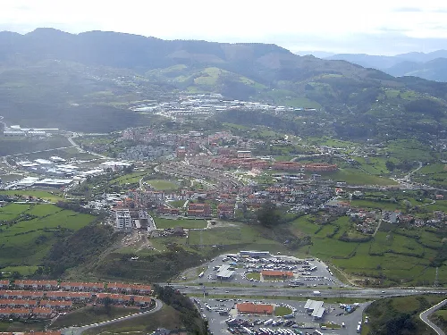 Vista aérea de Gallarta, con montañas y viviendas en un paisaje verde.