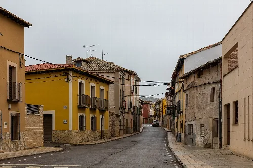 Narrow streets with old houses and cloudy sky in Romanones.