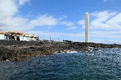 Leuchtturm Arenas Blancas an der Küste von Villa de Mazo, La Palma, mit Felsen und Häusern in der Nähe.
