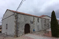 Church of San Pedro Apóstol in Villasrubias with stone walls and wooden arch.