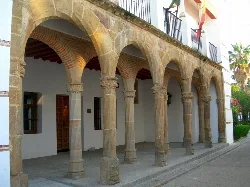 Fassade des Inquisitionstribunals in Llerena mit Bögen und Steinsäulen.