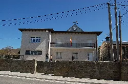Town hall building with clock and flag in Asturianos, Zamora