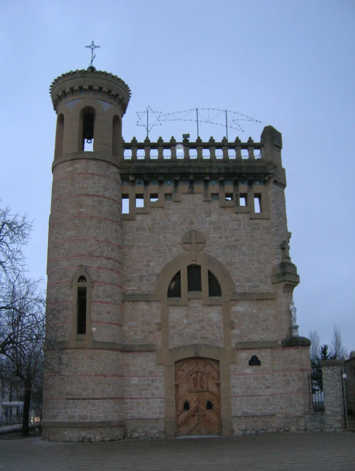 Church facade with tower and cross in Puebla de Don Fadrique.