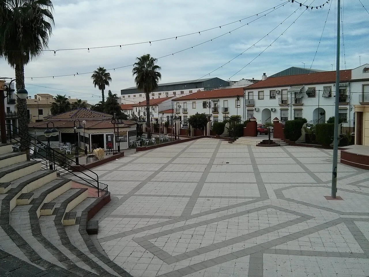 Platz mit Palmen, weißen Häusern und Lichtern in Villafranca de Córdoba.