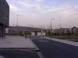 Blick auf eine Baustelle mit Gebäuden und Kränen im Hintergrund.