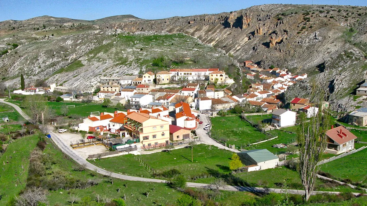 Panoramic view of Pontones with white and red houses in a mountain valley.