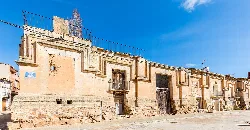 Fachada de un palacio en Used, Zaragoza, con detalles en piedra y cielo azul.