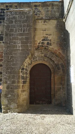 Tür der Kirche mit Steinbogen und Dekorationen in Petilla de Aragón.