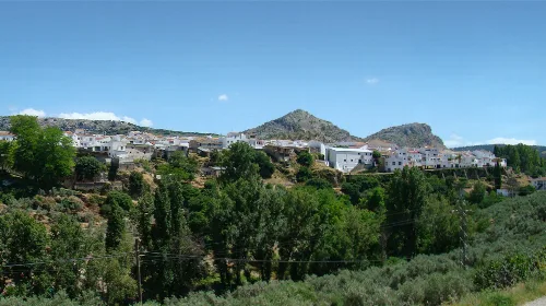 Ansicht von Cuevas del Becerro in Málaga mit weißen Häusern und Bergen im Hintergrund.