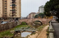 Steinerne Brücke in Monzón mit Gebäuden und kleiner Fußgängerbrücke.