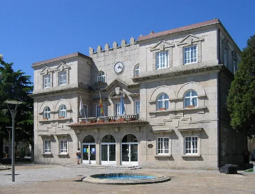 Edificio del ayuntamiento de O Grove con fachada de piedra y reloj en la parte superior.