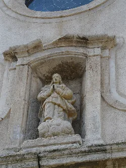 Religious figure sculpture on the church facade in Capafonts