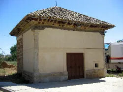 Small hermitage with tiled roof and light-colored walls in Osorno la Mayor.