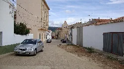 Calle real en Talayuelas con edificios y coches.