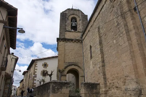 Church and street in Villatuerta, Navarra, with partly cloudy sky.
