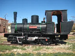Old black locomotive with green details and an open cab.