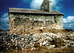 Ansicht der Kirche Santa María de La Golosa mit alten Ruinen im Vordergrund und moderner Struktur im Hintergrund.