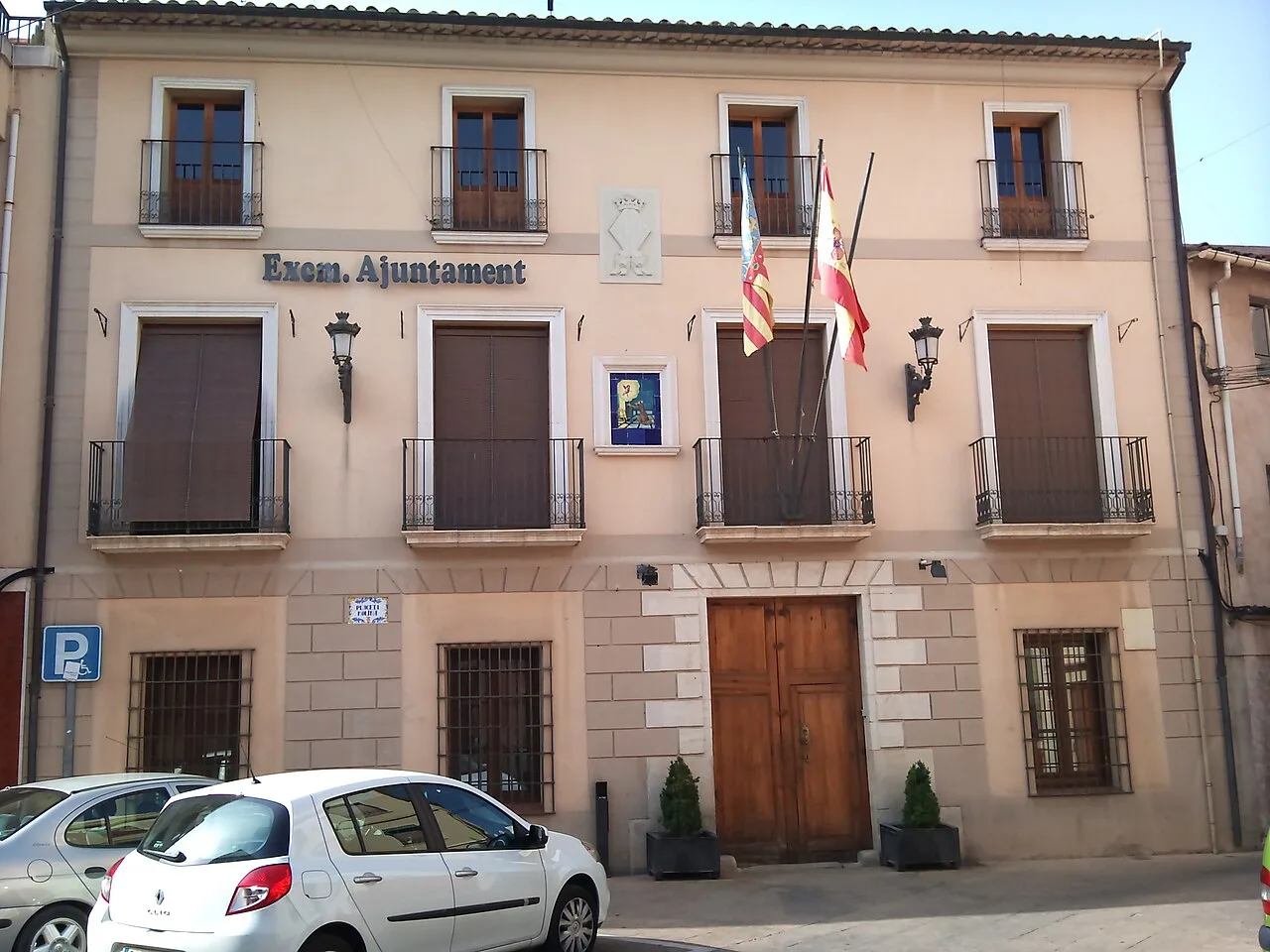 Edificio con fachada de piedra y dos banderas en la fachada del ayuntamiento.