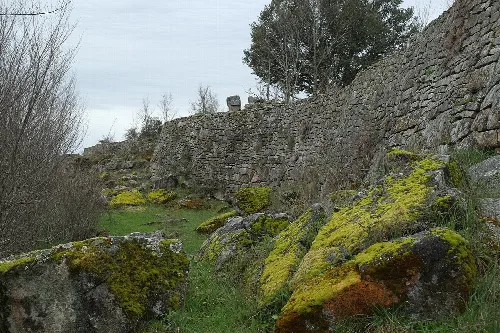 Restos de un castro con muros de piedra y vegetación en Yecla la Vieja.