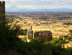 Stadtmauern von Trujillo mit ländlicher Landschaft und Himmel im Hintergrund.