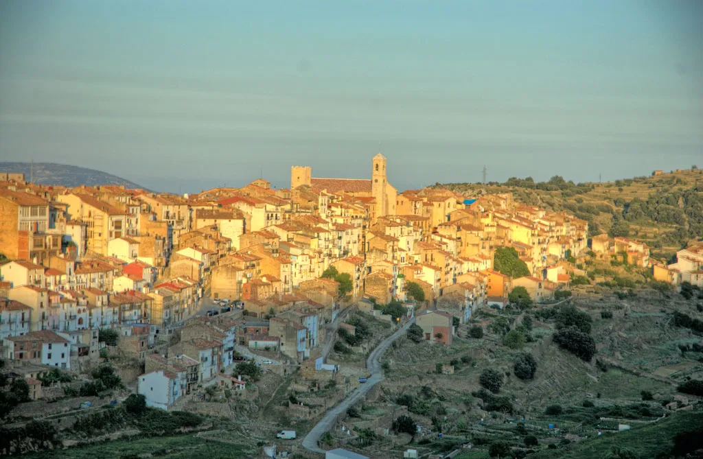 Vista panorámica de Villafranca del Cid con casas y torres en la colina.