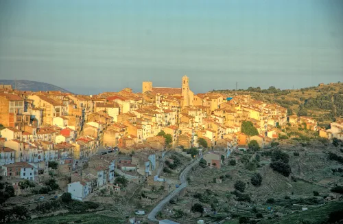 Vista panorámica de Villafranca del Cid con casas y torres en la colina.