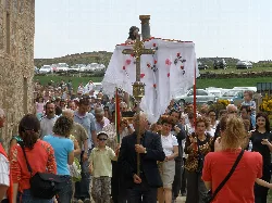 Hombre con cruz decorada en procesión durante la romería en Ambas Aguas.