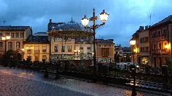 Bandstand in Noreña in a square with street lamps and old buildings.