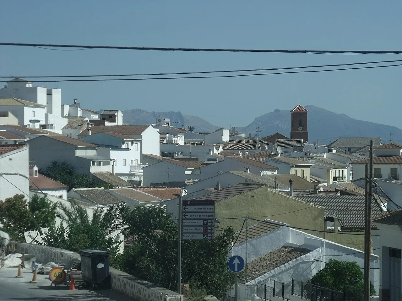 Blick auf weiße Häuser und Dächer in Villanueva de Tapia mit Bergen im Horizont.