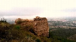 Restos de una torre de piedra en Albaida con paisaje de fondo.