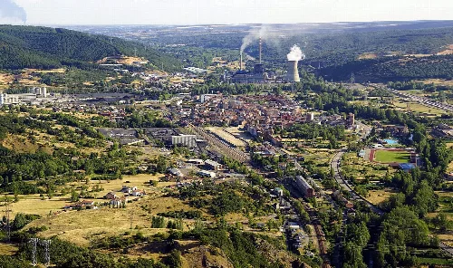 Panoramablick auf La Robla mit Fabriken, Eisenbahnen und ländlicher Landschaft.