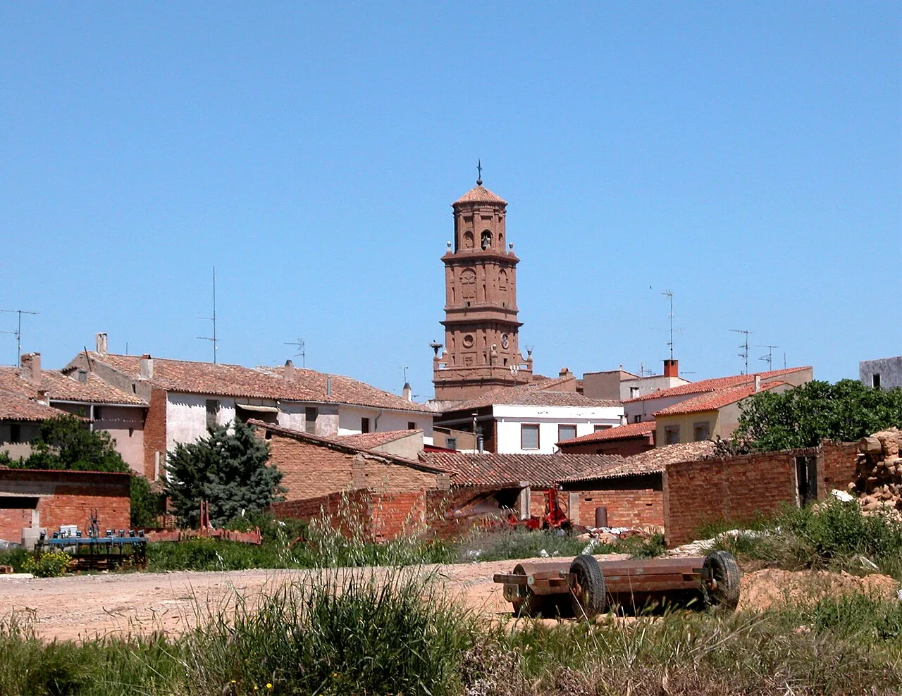 Blick auf den Turm und die Häuser von Aldeanueva de Ebro in einer ländlichen Umgebung.