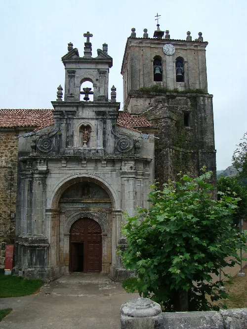 Fachada de piedra y torre de la iglesia en Miera, Cantabria.