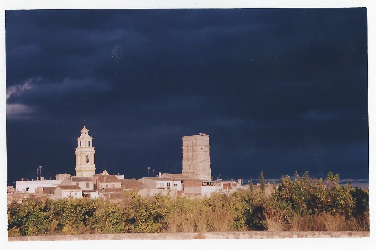 Panorama von Antella mit Turm und Glockenturm, dunkler Himmel.